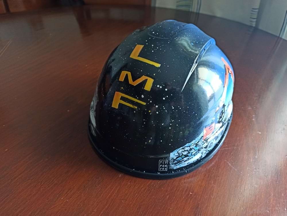 Vista traseira do capacete personalizado, onde se destacam as iniciais do cliente e o fundo esfumado criado com spray. O design é finalizado com o toque pessoal e um acabamento profissional.