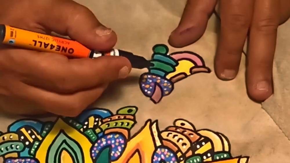 Close-up da pintura na textura da camurça, destacando a durabilidade e saturação da cor alcançada com a técnica de marcadores One4all.