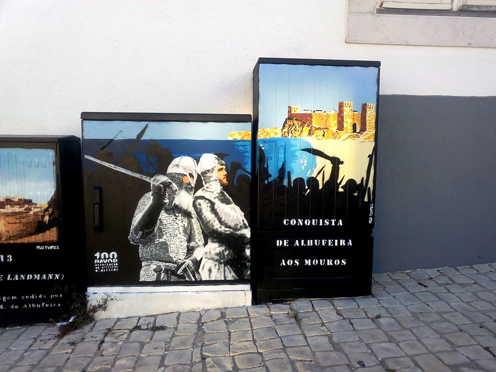 Pintura "O Cerco de Albufeira" terminada no local do antigo Castelo. Dois guerreiros cristãos a cinza estão em primeiro plano, prontos para o assalto. Ao fundo, o Castelo de Albufeira surge em cores reais (a recompensa). Técnica Stencil e Spray.