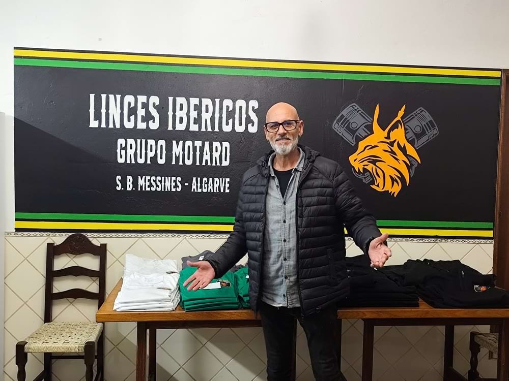 Mural do logótipo horizontal dos Linces Ibéricos GM, na parede do bar, com o artista de braços abertos no centro, durante a inauguração.