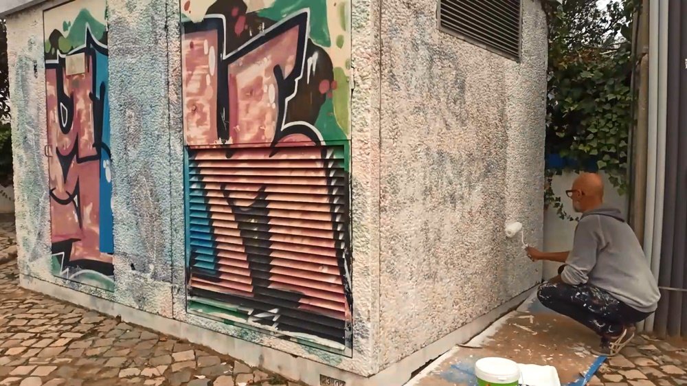 Início da aplicação do primário no Posto de Transformação (PT) em Almancil. A camada de primário cobre os graffiti anteriores, preparando a superfície para o mural "Tradição, Fé e Património Agrícola".
