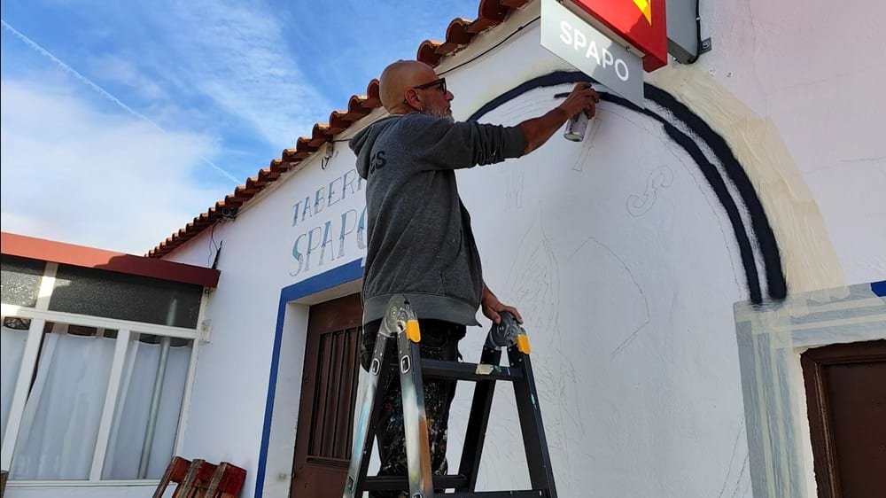 Artista a iniciar o mural exterior dos Linces Ibéricos GM, pintando os círculos exteriores do logótipo.