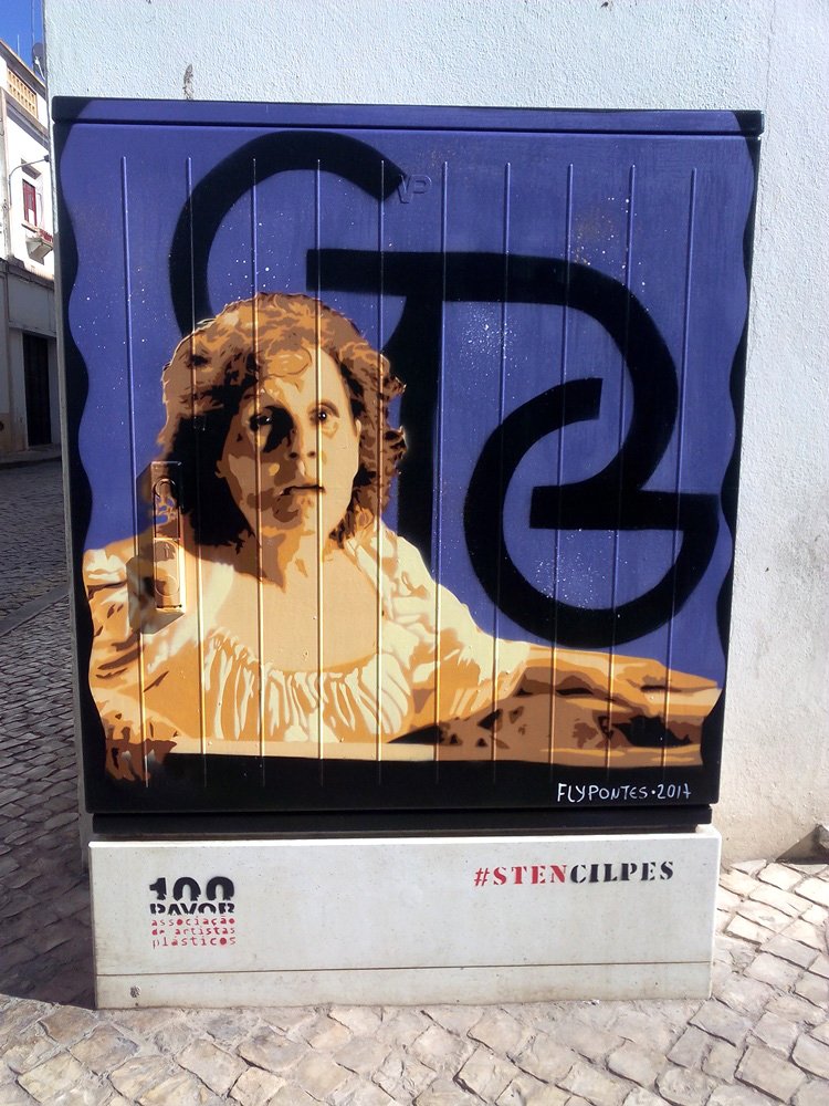 Pintura "Homenagem a Lisete Martins e ao Penedo Grande" terminada em S. B. Messines. O retrato realista de Lisete Martins em performance dramática está no primeiro plano, com o Logótipo do Teatro Penedo Grande no fundo. Homenagem à arte cénica e à cultura local. Técnica Stencil e Spray.