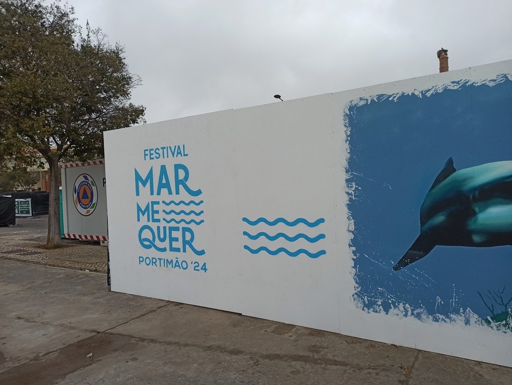 Logotipo do Festival Mar Me Quer finalizado no mural de Portimão. Vê-se ainda parte do Tubarão-Branco e o acabamento da pintura. Confirmação da execução da arte urbana no âmbito do Festival Mar Me Quer.