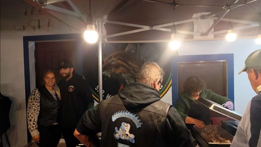 Mural realista do Lince Ibérico terminado, com várias pessoas a confraternizar à frente durante a festa de inauguração da sede.