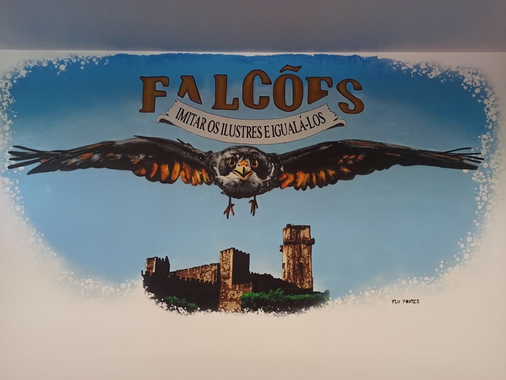 Mural "Os Falcões" terminado no Clube de Praças da BA11 em Beja. A obra apresenta o Falcão imponente, o lema "Imitar os Ilustres..." e o Castelo de Beja ao fundo, fortalecendo a identidade institucional do clube.