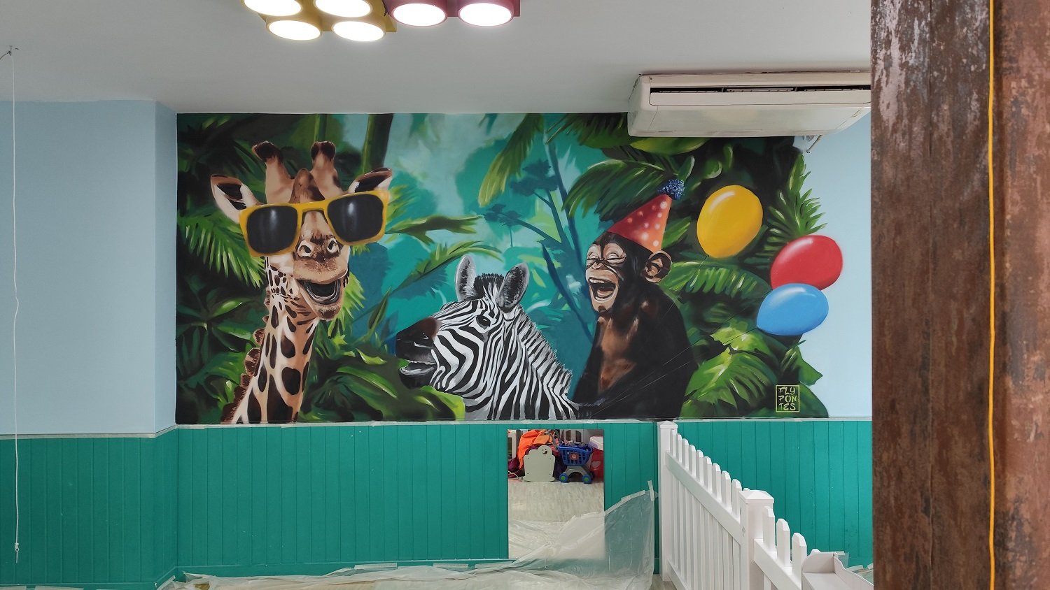 O "Mural da Selva" finalizado no "Eat, Learn and Play" em Albufeira. Pintura de 4x2,8m em estilo street style com girafa de óculos e macaco nas costas de uma zebra. Arte vibrante com spray para ambiente lúdico.
