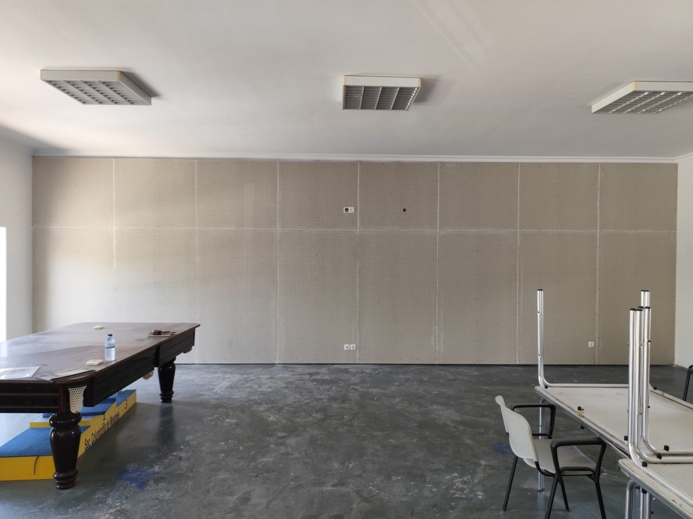 Foto da parede da Sociedade Columbófila Messinense sem tinta, antes da execução do mural "Tributo ao Pombo-Correio". A parede está pronta para receber a arte urbana em S. Bartolomeu de Messines.