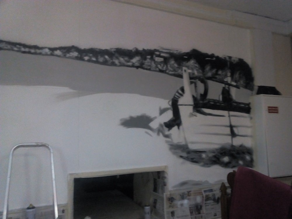 Processo a meio do mural "O Pescador de Armação de Pêra". A imagem mostra o Barco próximo do Pescador e a Falésia, todos em tons de cinza. Faltam ainda alguns detalhes na areia para a finalização da cena monocromática.