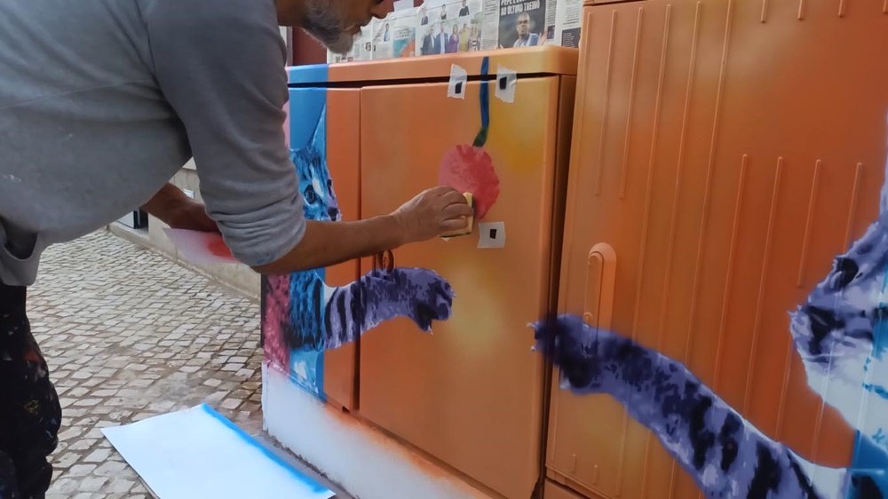 Os gatos já prontos no mural "Gatinhos Pop". O artista Fly Pontes cria textura na bola (novelo), usando uma esponja. Detalhe da aplicação de efeitos especiais e finalização da arte urbana em S. B. Messines.