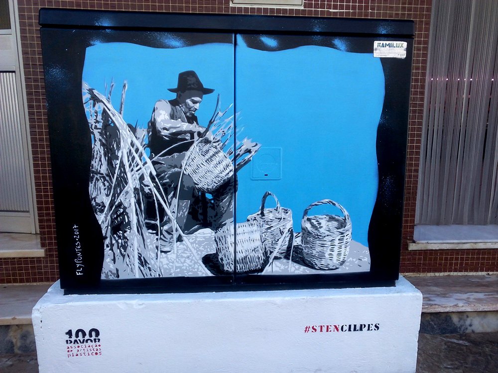 Pintura "O Último Cesteiro" terminado em S. B. Messines. O artesão e os cestos de vime estão pintados em tons de cinza (memória) em forte contraste com o fundo azul vibrante (presente). Homenagem ao artesanato local. Técnica Stencil e Spray.