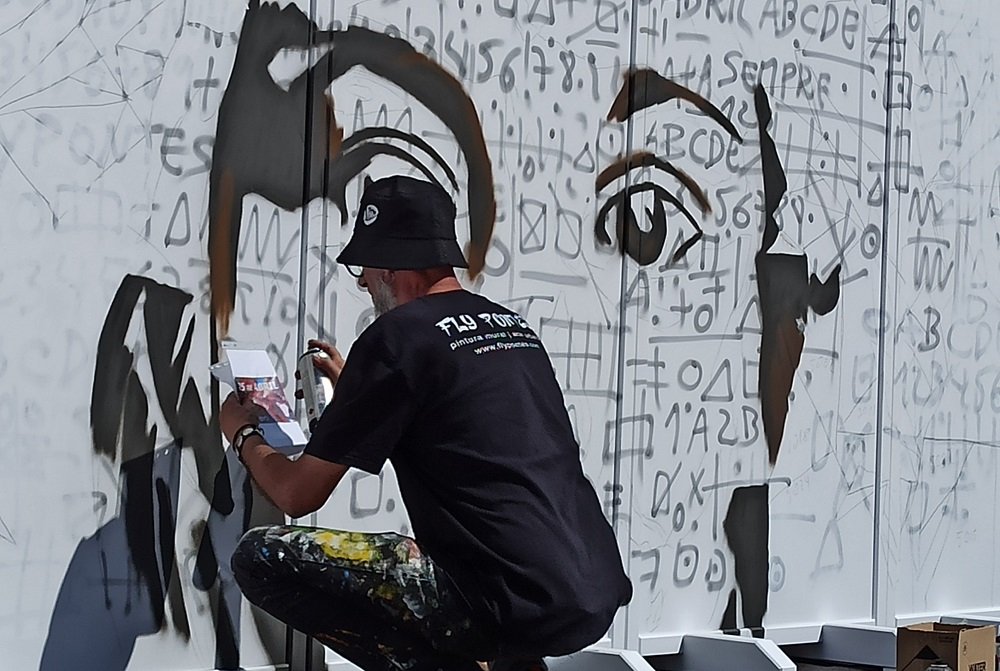 Fly Pontes a pintar o rosto central segurando folha de referência, com linhas de carvão visíveis para os cravos.