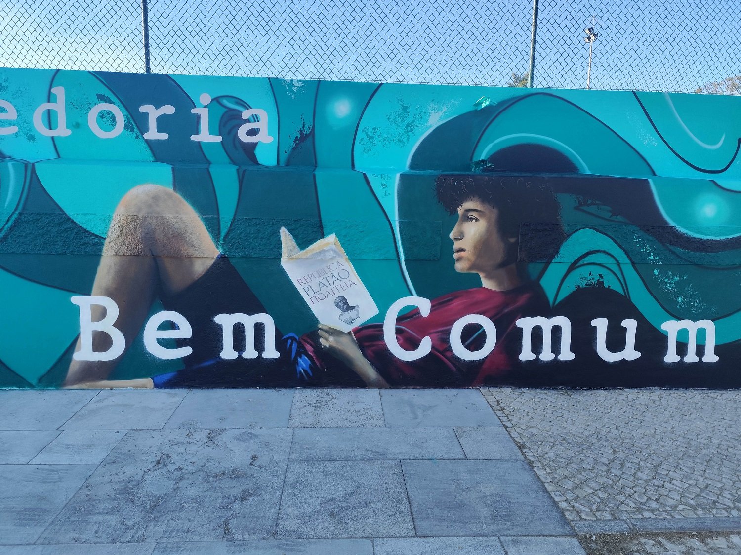 Detalhe da pintura de um jovem estudante a ler A Republica de Platao no mural POLITEIA