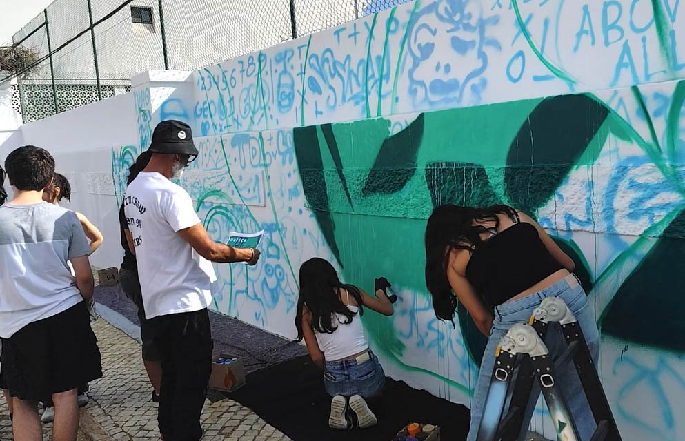 Alunos da Escola Secundaria de Silves a aplicar tinta de spray no fundo do mural POLITEIA
